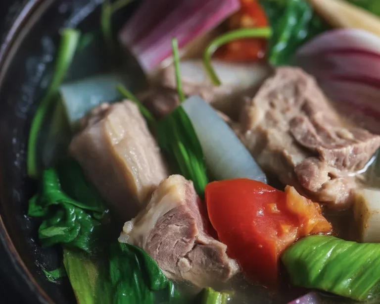 Delicious Filipino sinigang soup with pork, tamarind, and fresh vegetables.